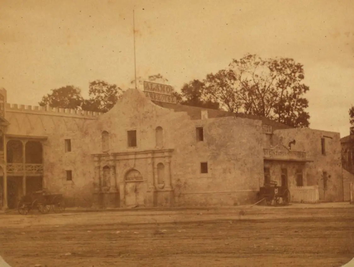 The Alamo church in the late 1870s, when the long barrack beside it was a store. Half of a Doerr & Jacobson stereoview.