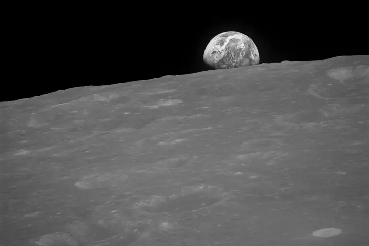 The first photograph of an Earthrise, the black-and-white frame Anders took seconds before he got color film (AS08-13-2329)