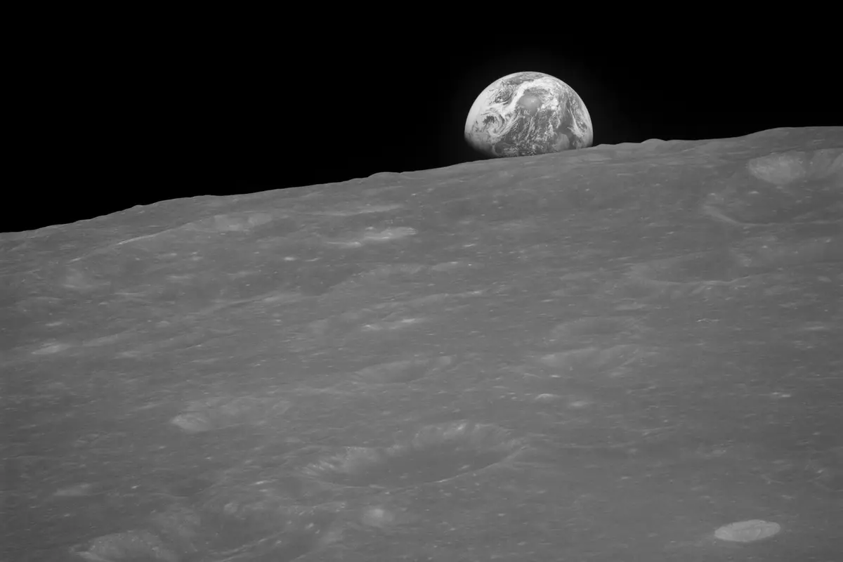 The first photograph of an Earthrise, the black-and-white frame Anders took seconds before he got color film (AS08-13-2329)