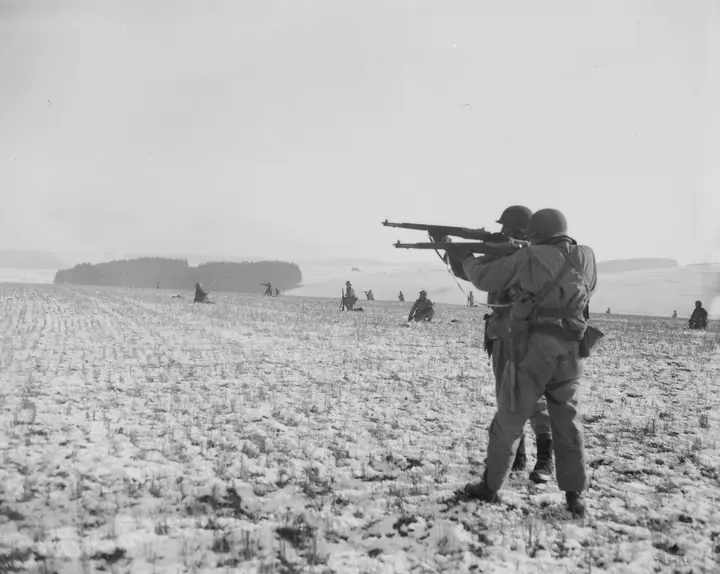 Infantrymen attached to the 4th Armored Division fire on German troops during the drive to relieve Bastogne, 27 December 1944