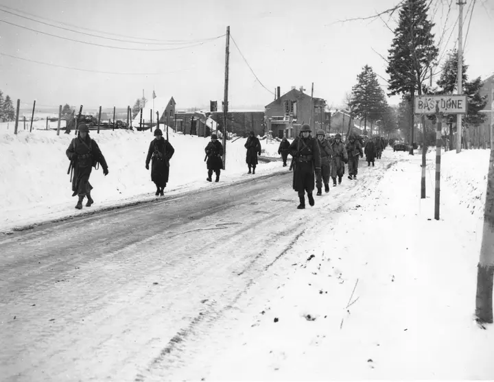 101st Airborne troopers move out of Bastogne after the ten-day siege, 1944