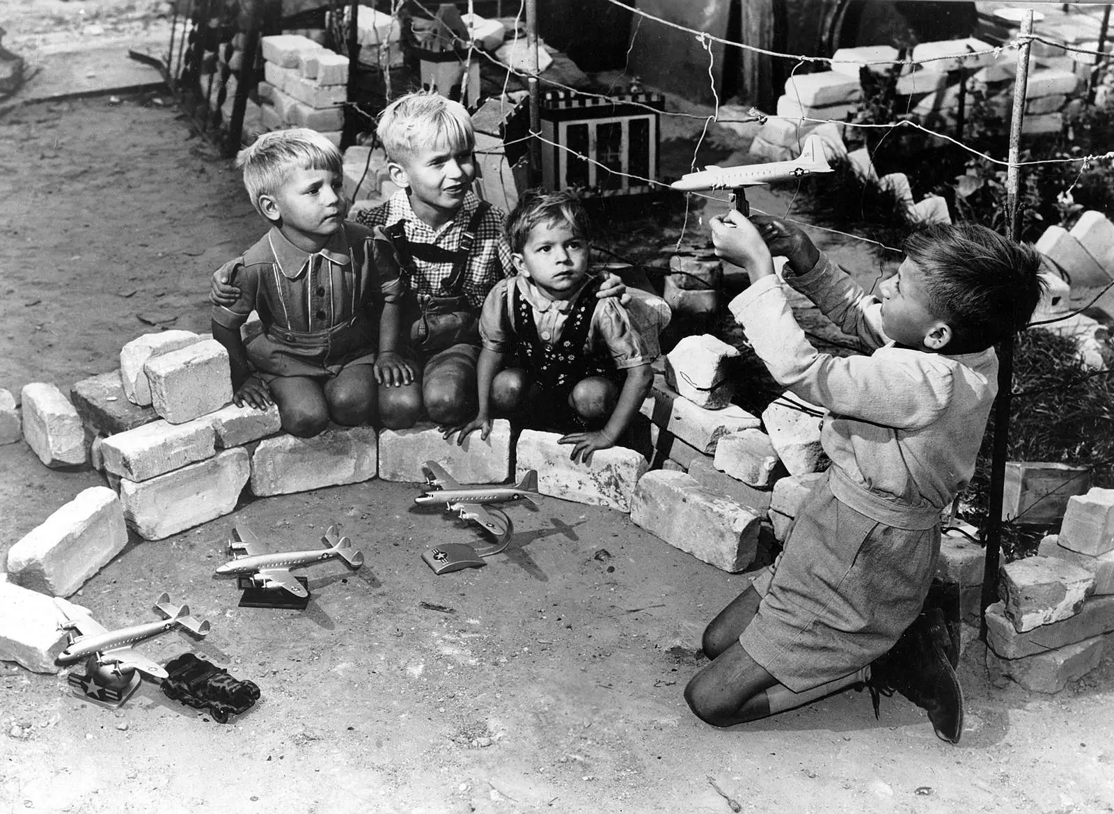 Children who live by Tempelhof play “Luftbrücke,” the airlift game, with model American planes, 1948.