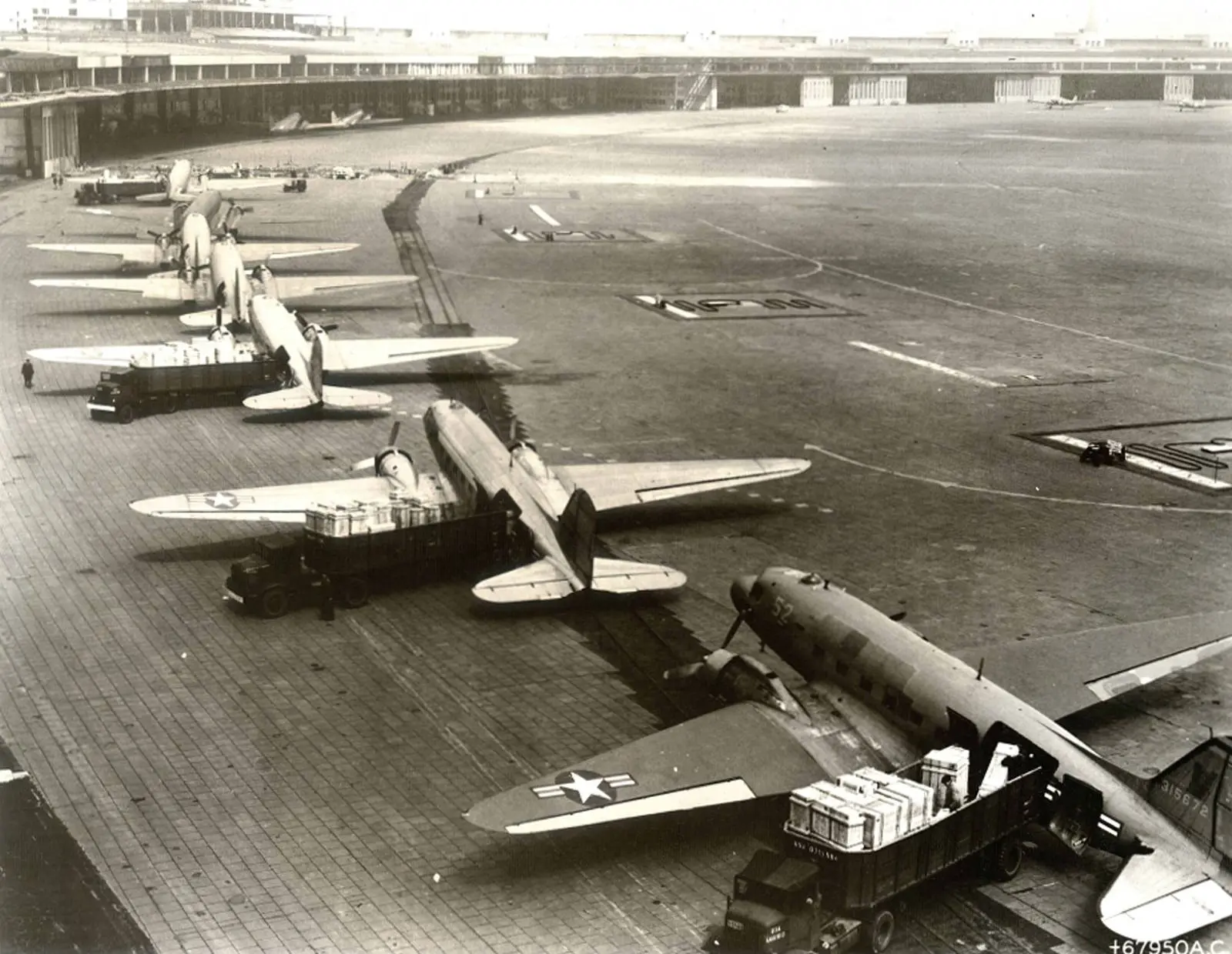 Air Force C-47s in the unloading line at Tempelhof. In the first weeks of the airlift these small twin-engine transports carried everything from engine crates to milk bottles.