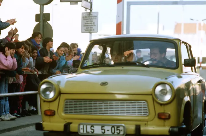 West Berliners cheer as East Germans drive through Checkpoint Charlie without border controls, November 1989