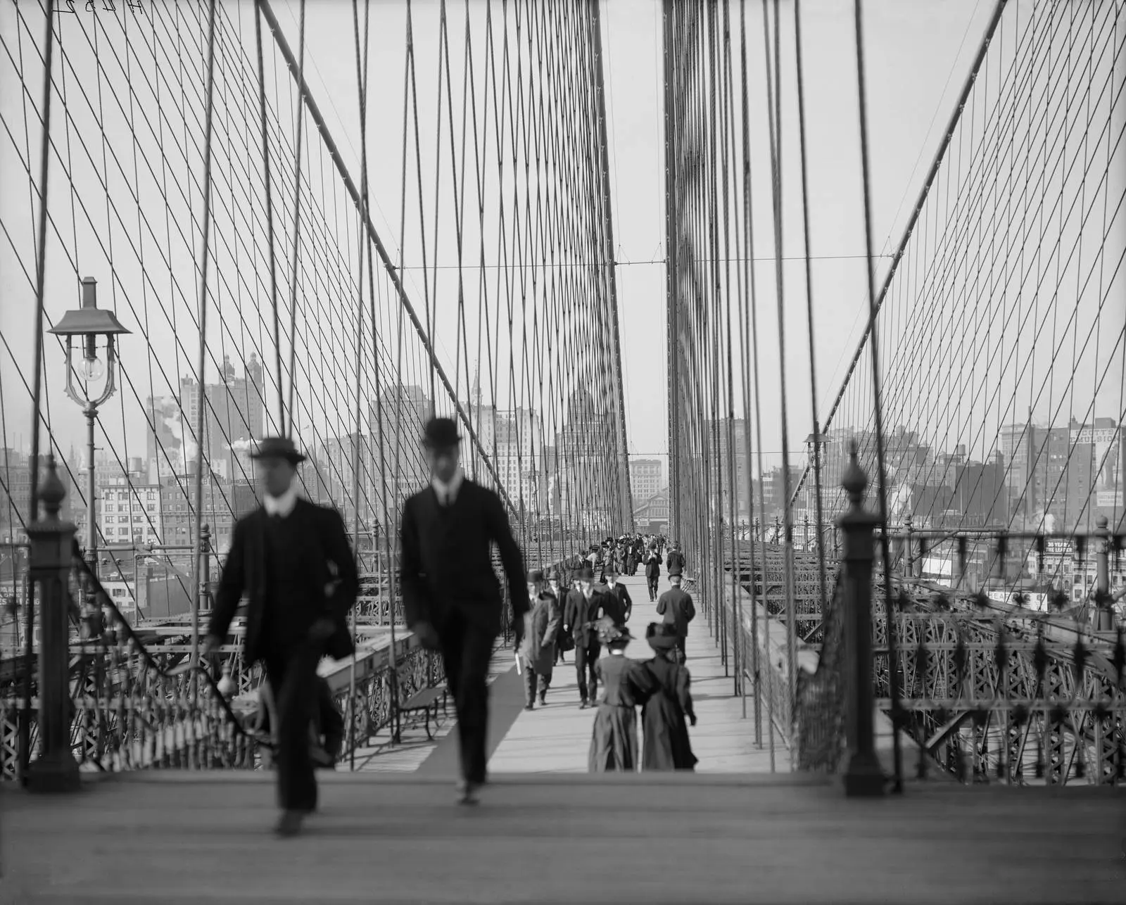 New Yorkers on the promenade, the raised walkway John Roebling designed for people on foot, early 1900s.