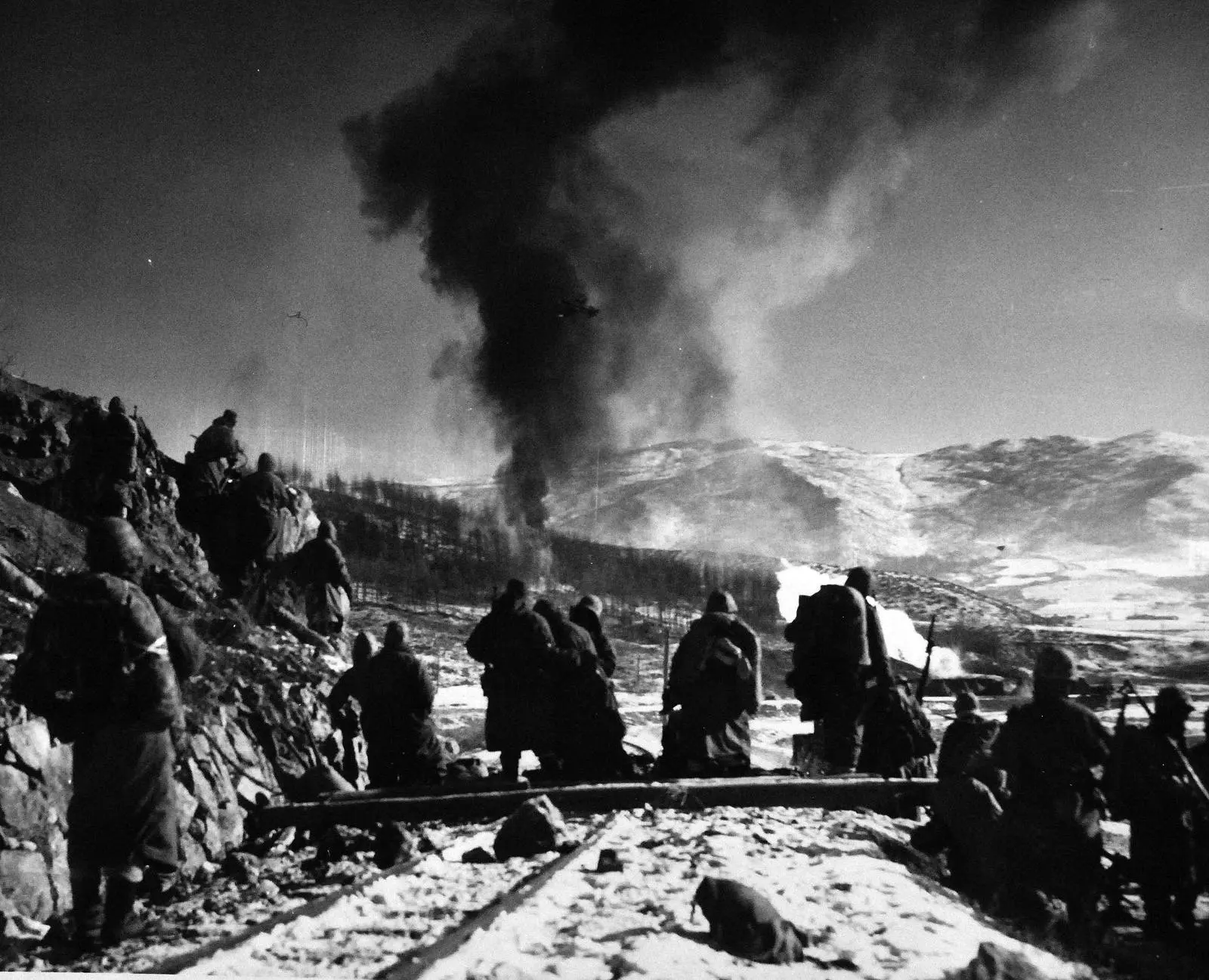 Marines move forward along the narrow-gauge rail line after close air support flushes the enemy from the hillsides, December 1950 (A-5439)