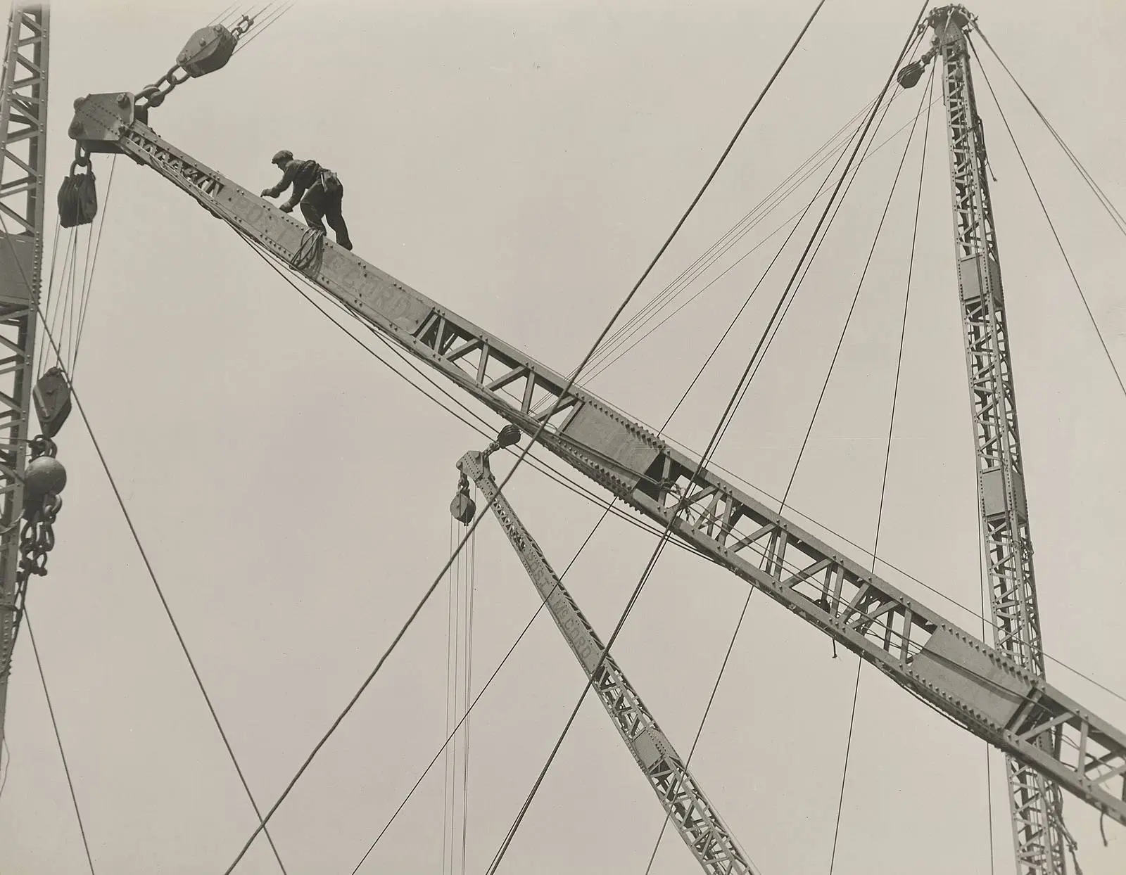 Jumping the derrick: an ironworker walks the boom of a derrick high over the city.