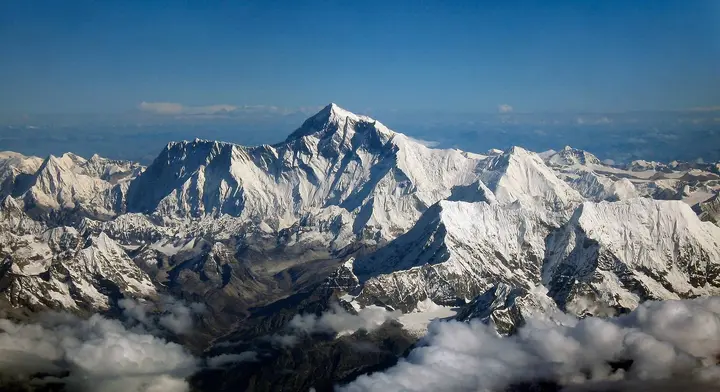 Everest rises above the Nuptse–Lhotse wall, seen from a Drukair flight south of the Himalaya.