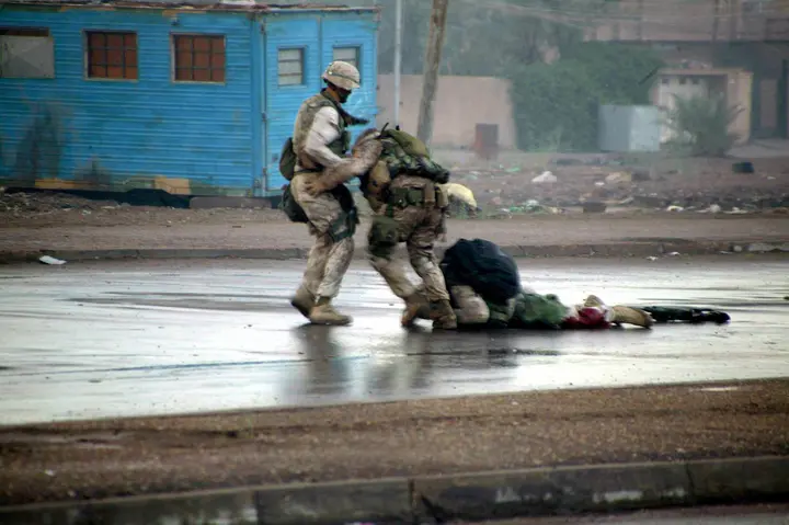 Gunnery Sgt. Ryan Shane (center) of 1st Battalion, 8th Marines, and another Marine drag a fatally wounded comrade to safety under fire, seconds before Shane was hit himself, 9 November 2004.