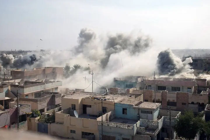 Smoke rises over Fallujah after an air strike on an insurgent stronghold, as Marines of 1st Battalion, 8th Marines, search the city, 10 November 2004.