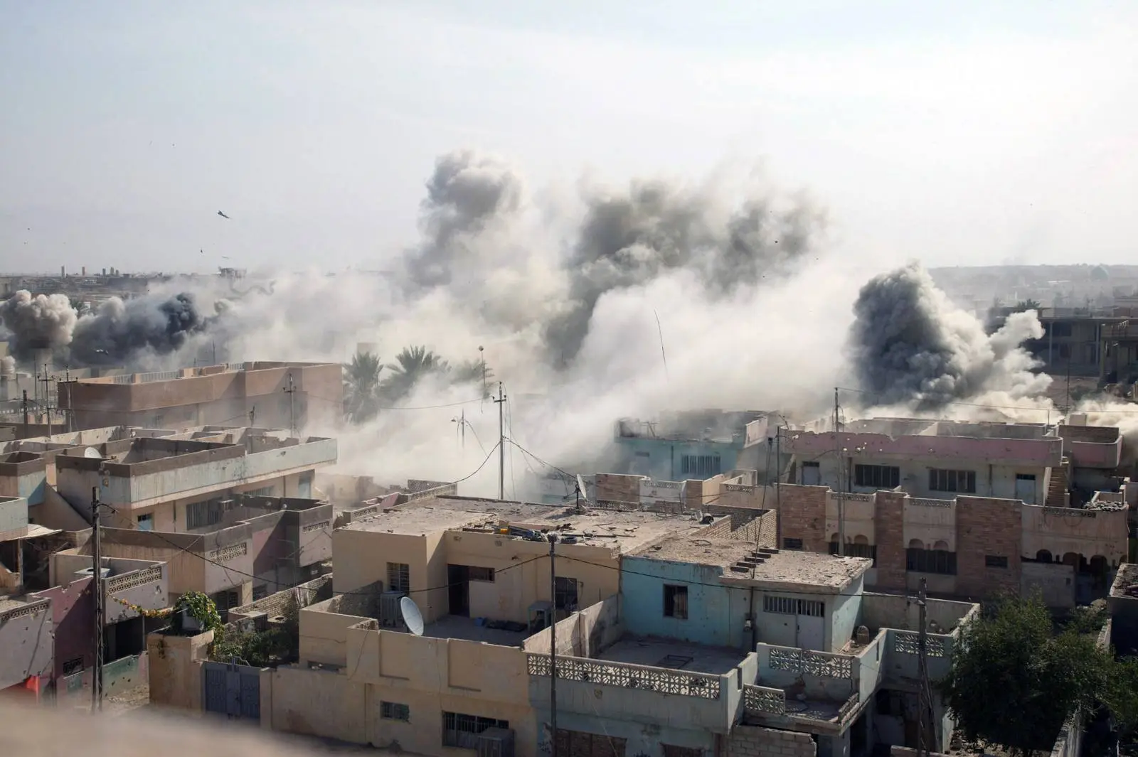 Smoke rises over Fallujah after an air strike on an insurgent stronghold, as Marines of 1st Battalion, 8th Marines, search the city, 10 November 2004.