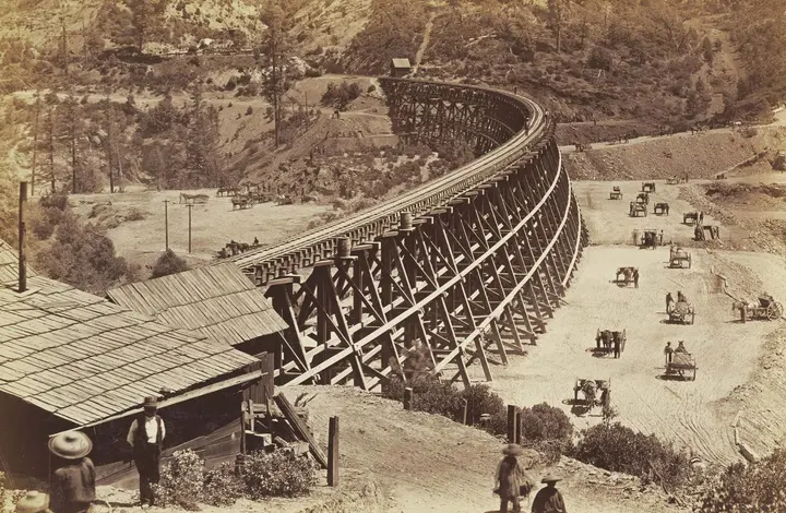 A Central Pacific timber trestle curving along a mountainside, photographed by Carleton Watkins in 1877
