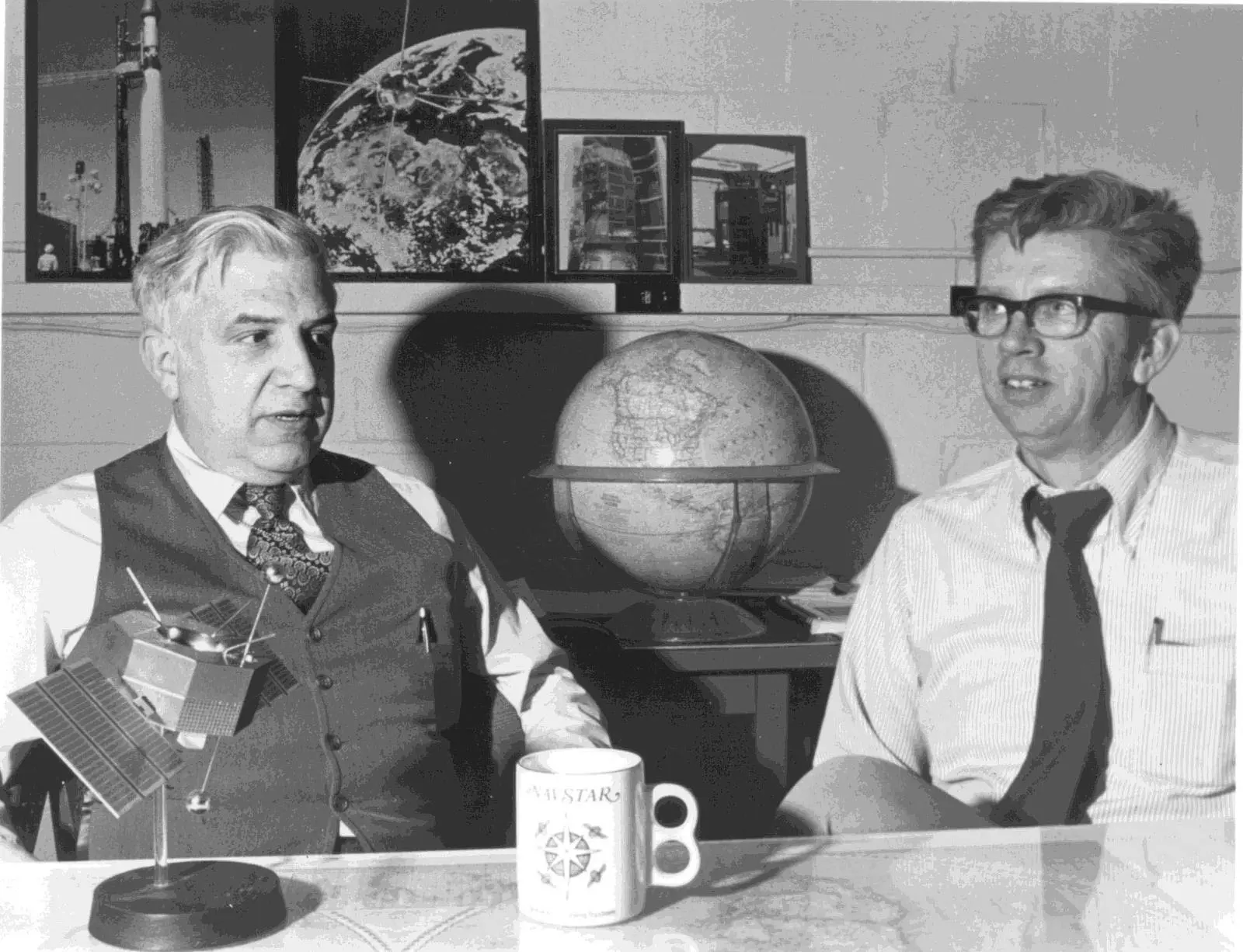 Roger Easton (left), who led the Naval Research Laboratory's Timation program, with a fellow NRL program manager and a satellite model.