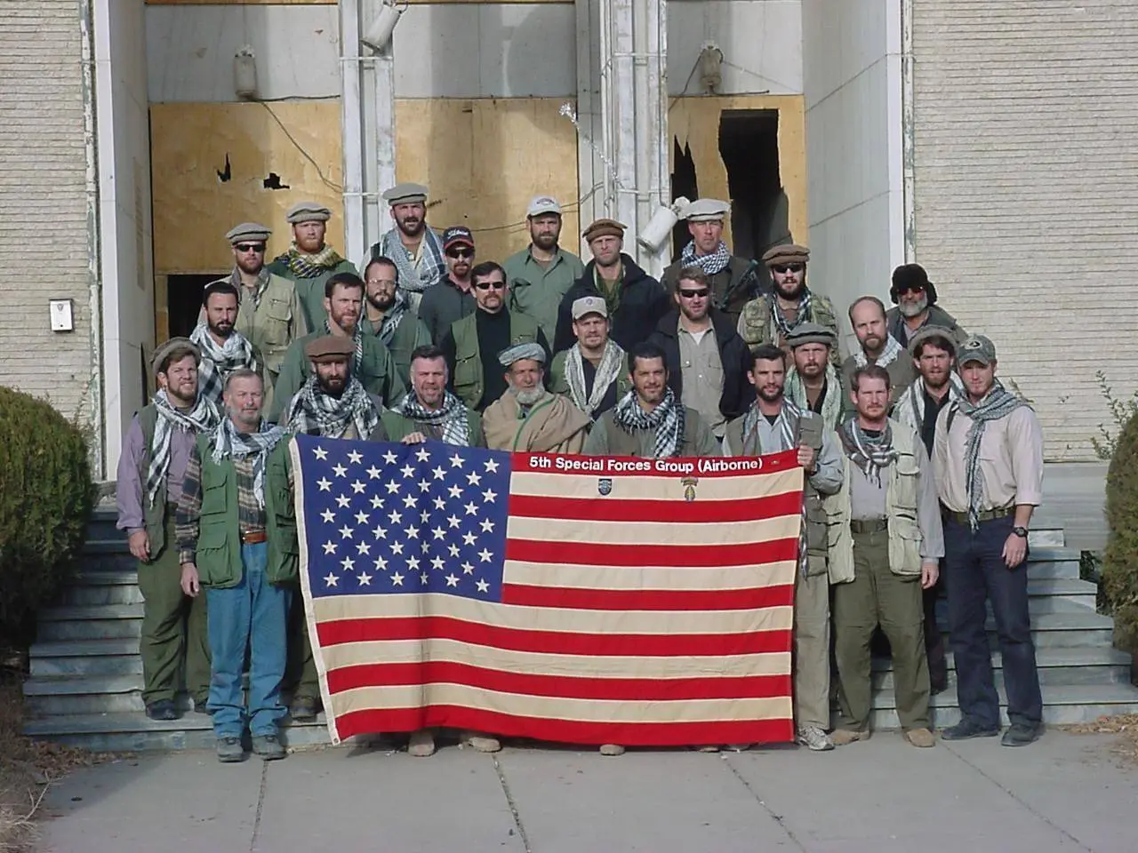 Green Berets of the 5th Special Forces Group and their Afghan allies with the flag, Afghanistan, late 2001