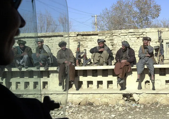 General Dostum’s fighters rest on a wall along the busiest street in a free Mazar-i-Sharif, 15 December 2001
