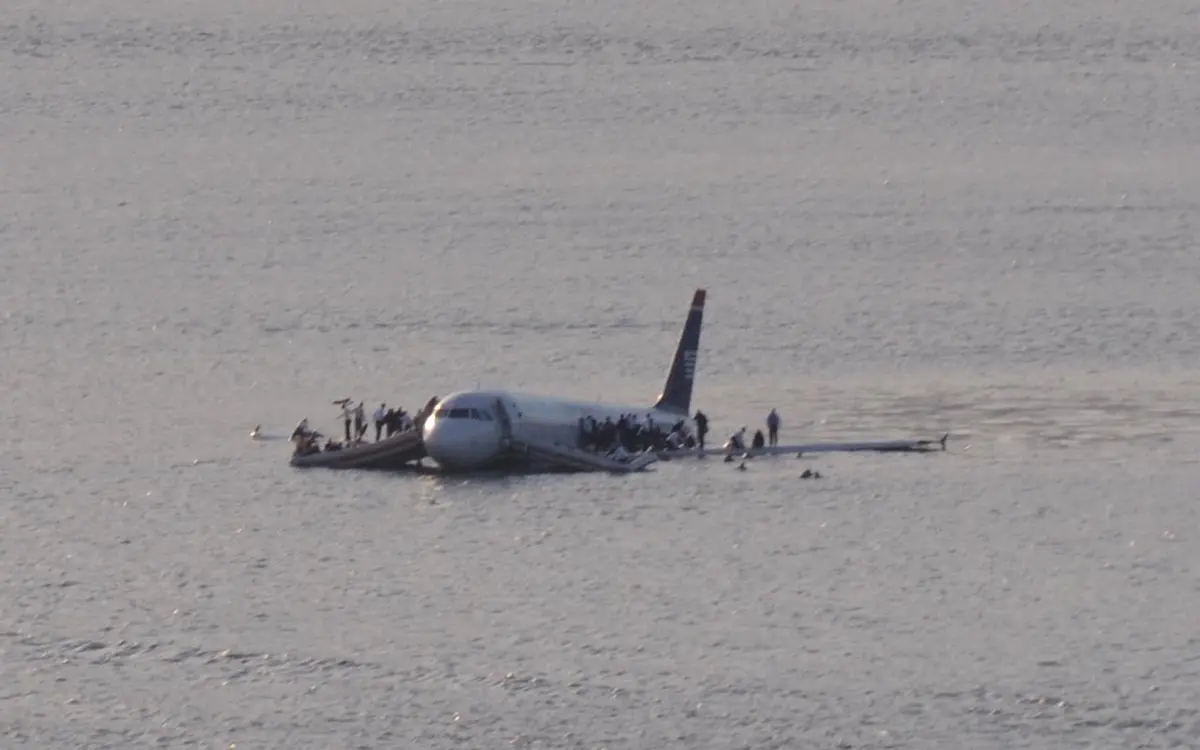 Passengers stand on the wings and crowd into the slide/rafts minutes after the ditching, before the first boat arrives