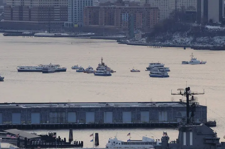 Ferries, fireboats and Coast Guard boats gather around Flight 1549 off Midtown Manhattan, with the USS Intrepid in the foreground