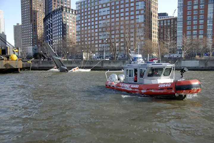 Coast Guard boat 25640, one of the boats that answered the ditching, guards the moored airliner at Battery Park City the next day