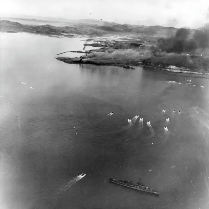 Landing craft of the first and second waves run in toward Red Beach, with the destroyer USS De Haven below, photographed from a Marine Corsair, 15 September 1950 (NH 42351).
