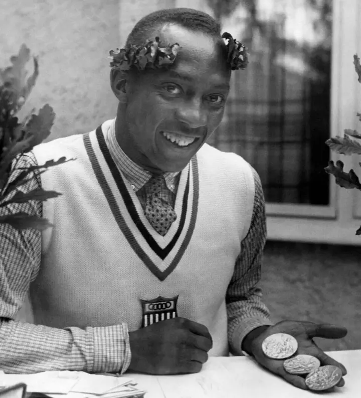 Still wearing his victor’s oak wreath, Owens holds his Olympic gold medals in Berlin, 1936