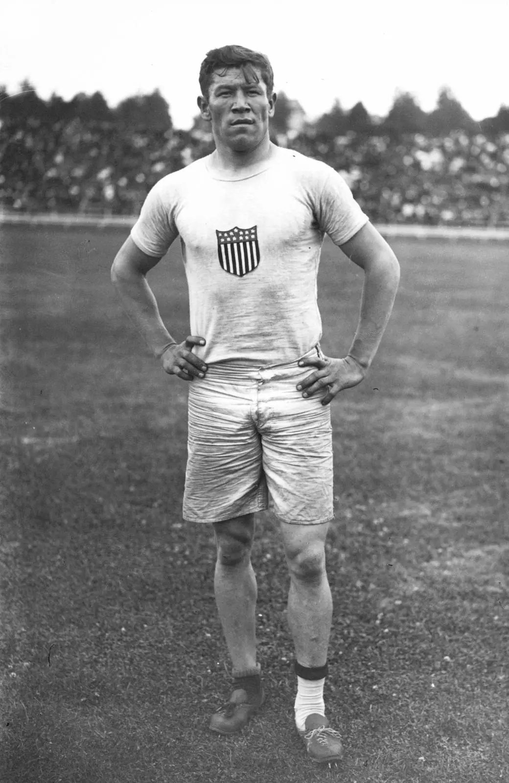Thorpe in his U.S. Olympic shirt, July 1912. His socks and shoes do not match, the detail behind the story of his stolen shoes