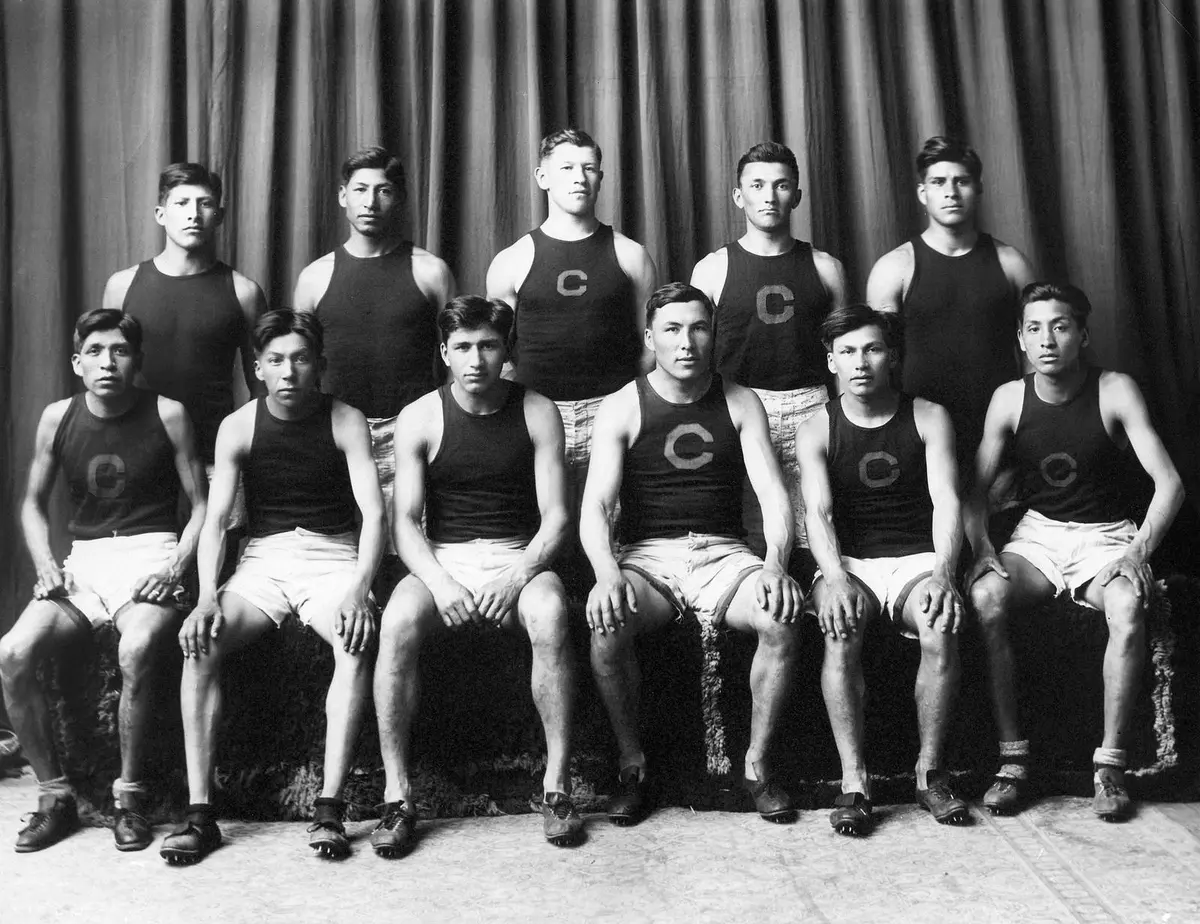 The 1912 Carlisle Indian School track team. Thorpe stands in the middle of the back row, and Tewanima sits at far left in front