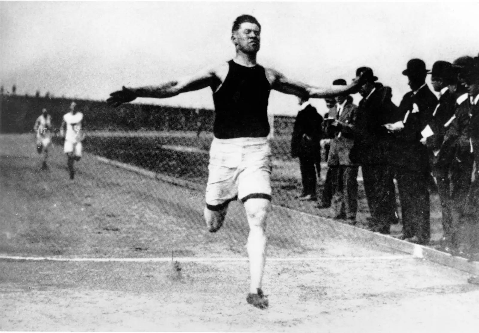Jim Thorpe spreads his arms as he crosses the finish line, 1912