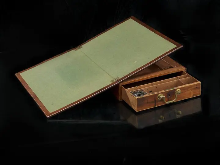 The portable desk on which Jefferson wrote the Declaration, its writing board open.