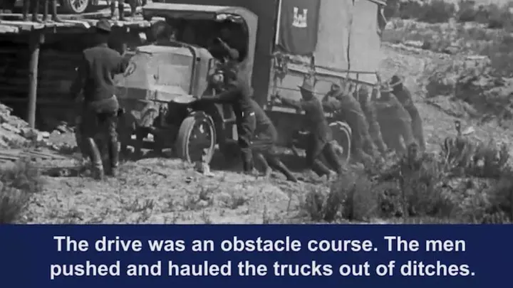 Soldiers push a stuck truck in film of the 1919 Army transcontinental convoy.