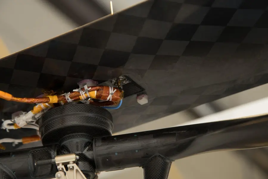 A swatch of Wright Flyer wing fabric wrapped around a cable beneath the solar panel of NASA's Ingenuity Mars Helicopter, 2021 (PIA24291)