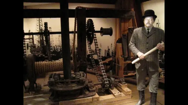 A figure of Capt. Anthony Lucas beside a rotary rig at the Texas Energy Museum