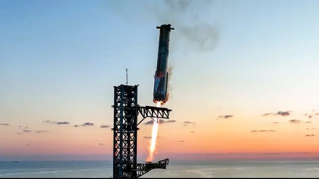 Super Heavy descends toward the launch tower at Starbase (video still).