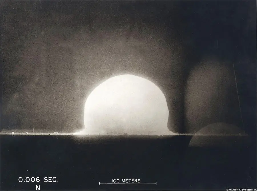 The Trinity fireball six thousandths of a second after detonation, with a 100-meter scale bar.