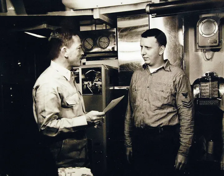 Beneath the North Pole, Anderson congratulates Electrician’s Mate First Class James R. Sordelet, the first man in history to reenlist at the Pole.