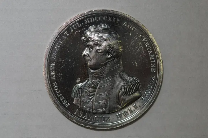 A silver striking of Isaac Hull’s Congressional Gold Medal. Its Latin honors his skill in the July escape and his courage in the August battle.