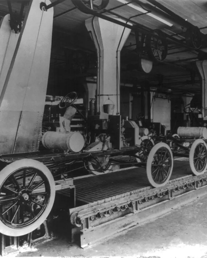 Model T chassis ride the moving line at Highland Park that Clarence Avery laid out. No free portrait of Avery is available.
