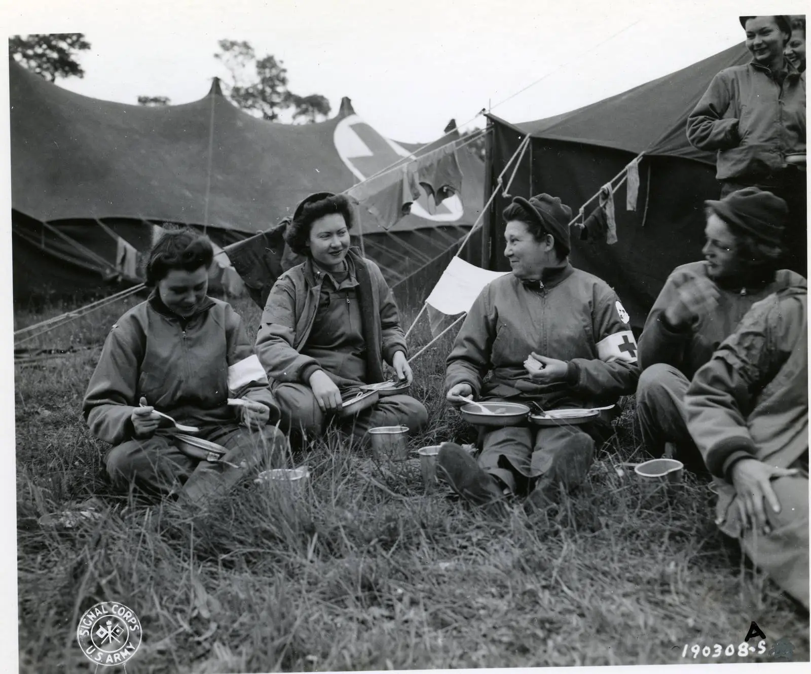 Nurses of the 13th Field Hospital, the first to arrive in Normandy to tend the wounded, take a break for chow at Omaha Beach, June 1944.