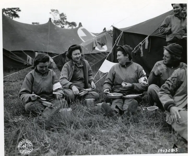 Nurses of the 13th Field Hospital, the first to arrive in Normandy to tend the wounded, take a break for chow at Omaha Beach, June 1944.