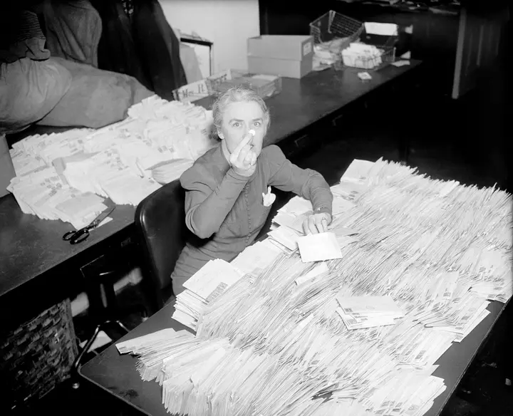 Missy LeHand, President Roosevelt’s secretary, digs through the first March of Dimes mail at the White House, 28 January 1938.