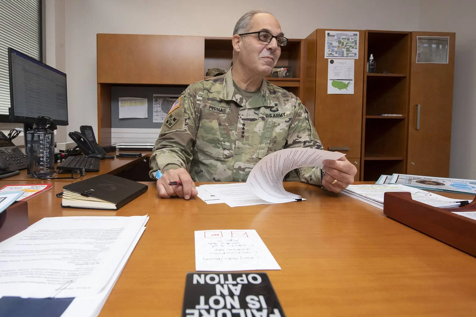 Gen. Gustave Perna at his desk at Operation Warp Speed headquarters, behind a sign that reads “Failure is not an option,” 13 November 2020.