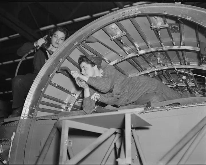 A team of women working inside a center wing section of a B-24E Liberator at Willow Run, 1942–43
